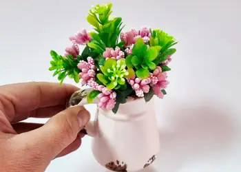 vas ceramic alb cu plante artificiale verzi si roz