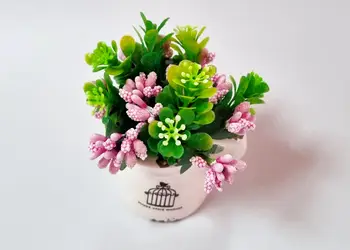 vas ceramic alb cu plante artificiale verzi si roz