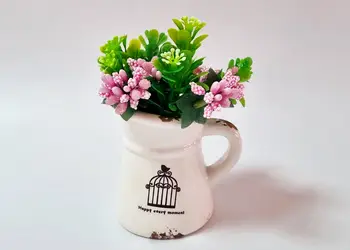 vas ceramic alb cu plante artificiale verzi si roz