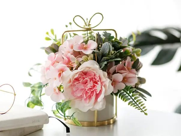 aranjament flori artificiale roz in vas ceramic alb si suport metalic auriu